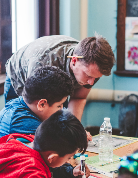 Teacher showing students at desks how to do a problem